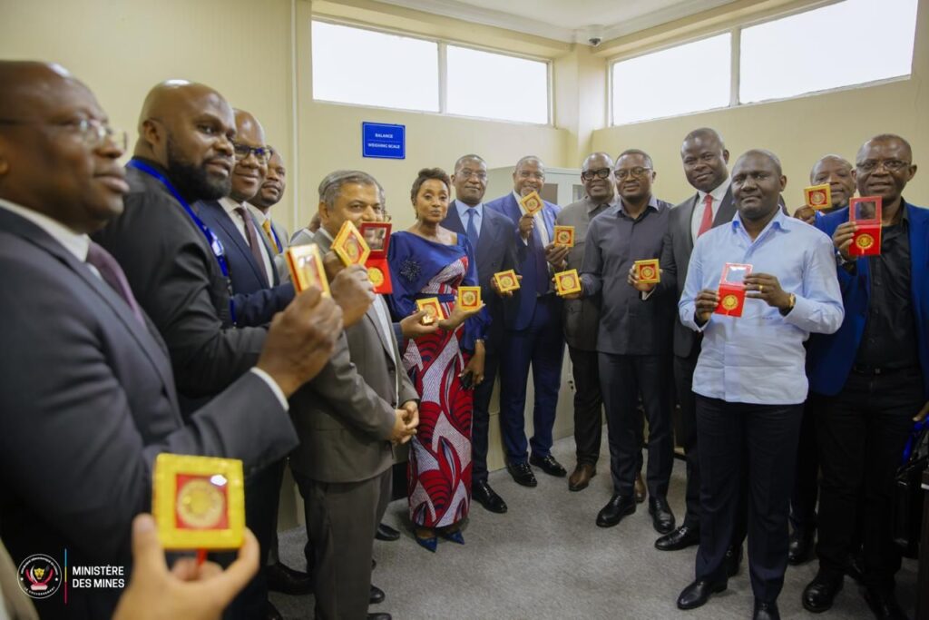 Officials and refinery staff holding refined gold bars at the launch of Congo’s first gold refinery